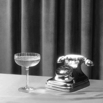 Vintage telephone beside a coupe glass